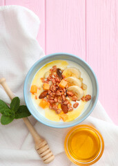 Yogurt with fruits, granola and nuts on the table top view.. Vertical photo format