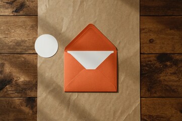 Top-down view of a card inside an orange envelope with a blank sticker on the table