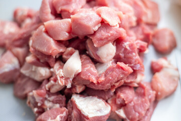 Raw meat with fat, cut into pieces close-up. Pink pork fat. Cut pork pieces for cooking. Fresh ingredients for marinating and barbecue. Fresh meat products