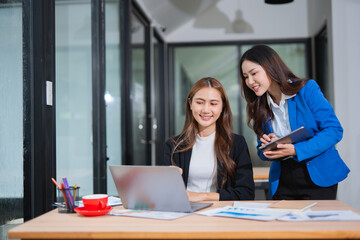  Accountants or business people working together on a project. Two female business colleagues are working on computers.
