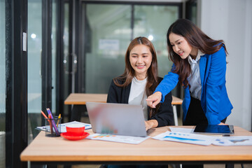  Accountants or business people working together on a project. Two female business colleagues are working on computers.