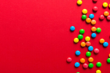 Mixed collection of colorful candy, on colored background. Flat lay, top view. frame of colorful chocolate coated candy