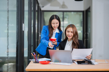 Accountants or business people working together on a project. Two female business colleagues are working on computers.