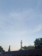 Obraz premium Peaceful mosque minaret against a serene blue sky offers spiritual tranquility and architectural beauty.