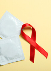 Condoms and red ribbon symbolizing AIDS. World AIDS Day. Vertical photo format