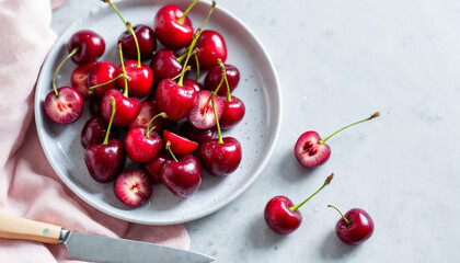 Close-up still life of fresh cherries on a speckled plate with soft lighting.	