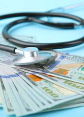 Medical stethoscope and money on a colored background top view close-up. Vertical photo format