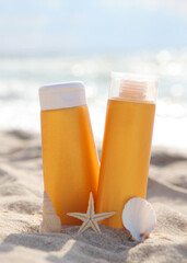 Sunscreens on the beach near the sea close up. Vertical photo format