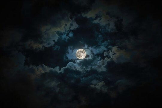 Bright moon glowing through tempestuous clouds