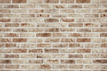 Expansive textured wall featuring cream and beige bricks combined with aged brown bricks and limestone, ideal for abstract backdrops