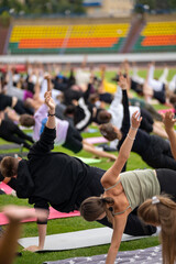 Group yoga session on stadium lawn in FYSM style