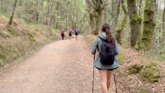 Young woman walking the Camino de Santiago from Sarria, joyfully exploring forest trails and city streets during her spiritual and cultural pilgrimage in northern Spain