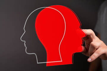 Stock photo of two overlapping head silhouettes, one red, one grey, representing dual perspectives or conflicting ideas.