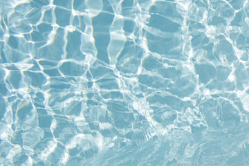 High-quality photo of a clear blue water surface with ripples and sunlight reflections. Ideal for backgrounds and designs.