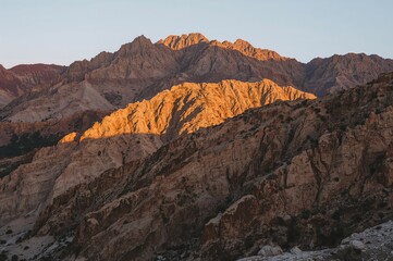 Fototapeta premium Rugged Arid Peaks Highlighted by Patches of Light and Shadow