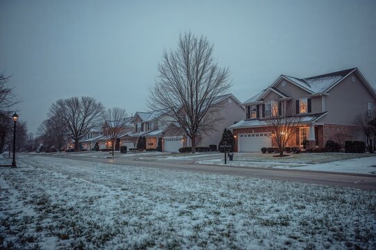 Suburban Street Lined with Houses Under Light Winter Snowfall