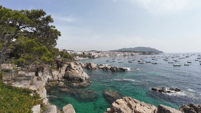 Calella de palafrugell coastline with boats on sunny day