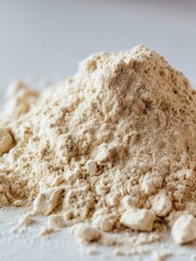 Close up studio shot of a pile of protein powder on a white surface showing its texture and consistency for nutrition