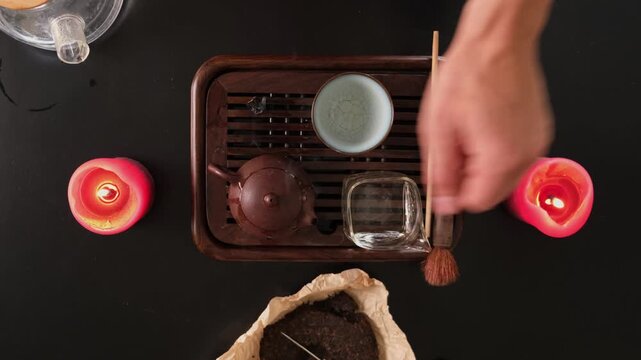 Traditional Chinese tea ceremony at home, pouring puer tea with gongfu cha method. Top view in authentic kitchen lifestyle.