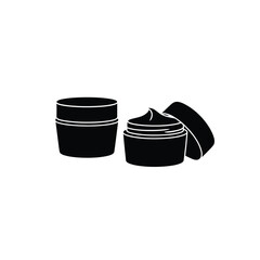 Two black cosmetic cream jars one open with lid beside it isolated on white
