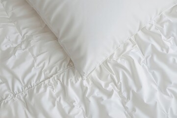 Close-up aerial shot of a white pillow on a bed with a rumpled blanket, capturing the aftermath of a long night's sleep, featuring an abstract white duvet texture.