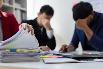 Stressed business team suffering headache and migraine in office meeting, stress from work overload, burnout syndrome, and frustration.