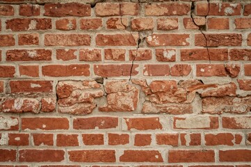 Fototapeta premium Aged red brick surface serving as an artistic backdrop. Coarse brickwork with visible joints creating texture.