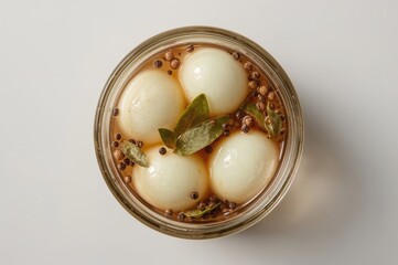 Glass Jar Containing Eggs Pickled with Apple Cider Vinegar, Coriander Seeds, Bay Leaves, and Black Peppercorns