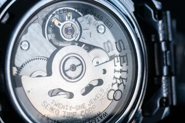 Gears and pendulum in wrist watch close up, transparent glass back of Seiko watch