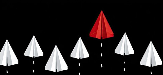 Red paper airplane stands out among white ones on black background