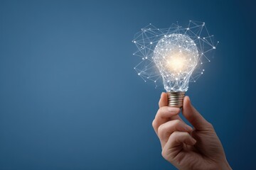 A hand holds a glowing lightbulb, with a network of lines and dots forming a design around it against a muted blue background