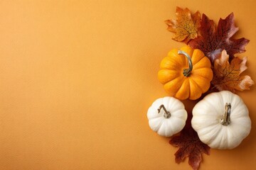 Halloween pumpkins and autumn leaves sit together on orange background, text space.
