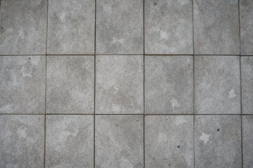 Top view of decorative stone tiles with a textured cement finish on a modern exterior floor