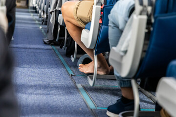 Bare foot airplane passenger with shoes removed during long haul flight for comfort travel © ThamKC