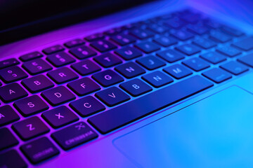 Laptop keyboard and touchpad with purple and blue ambient lighting computer technology