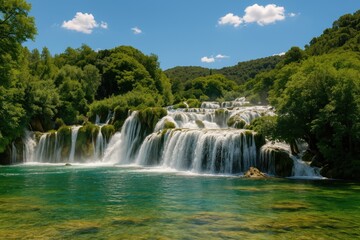 Obraz premium Bright weather with a cascading waterfall in a scenic nature reserve