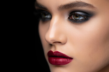 Close-up Profile of Woman with Dramatic Smoky Eye Makeup and Deep Red Lipstick, Elegant and Mysterious Beauty Shot.