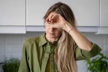 Weak tired woman covering face at home, feeling sudden illness with nausea and near fainting...