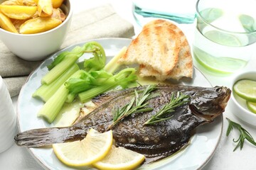 Tasty roasted flounder fish with celery served on white table, closeup. Homemade seafood dish