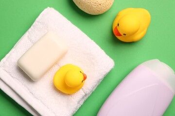 Baby bath accessories on green background, flat lay