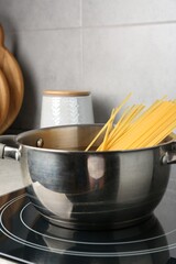Fresh tagliatelle pasta boiling in pot on electric stove