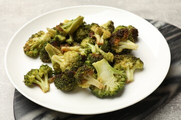 Tasty fried broccoli on light grey table, closeup