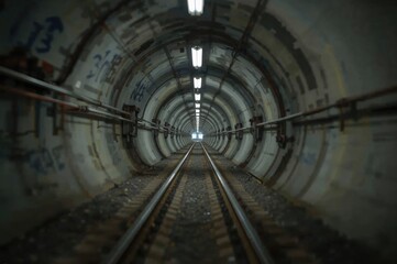 Obraz premium Engineer or technician in soft focus with blurred lighting, overseeing underground tunnel infrastructure. Transport pipeline created by Tunnel Boring Machine for electric train system