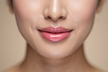 Fototapeta premium Close-up of woman's lips with glossy pink lipstick, subtle smile, soft lighting, beauty and cosmetics concept.