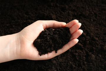 Woman with pile of fresh soil, closeup