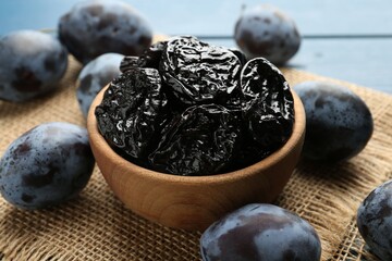 Dried prunes and fresh plums on table, closeup