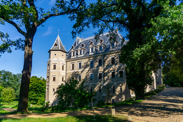 Fototapeta premium Historic Castle in Gołuchów, park side view, corner tower, historic architecture surrounded by greenery.