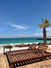 Empty wooden deck chairs on the beach with sea view 