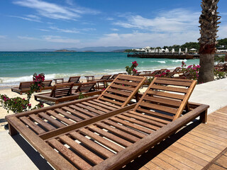 Obraz na płótnie Canvas Empty wooden deck chairs on the beach with sea view 