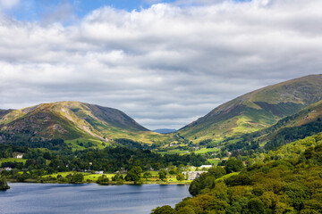 Fototapeta premium Lush green valley and fells surrounding the village of Grasmere on a cloudy summer day